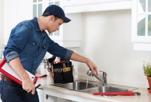 Plumber installing a new kitchen faucet